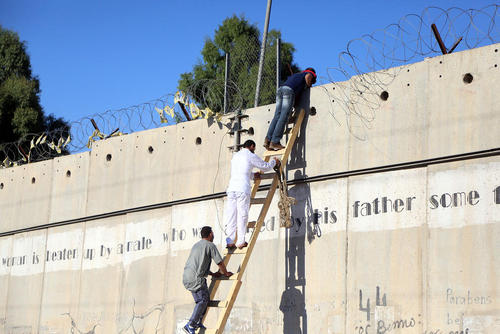 تلاش فلسطینی ها برای عبور از دیوار حائل اسراییل/عکس