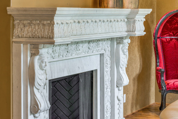 تزئینات اطراف شومینه به رنگ سفید نقاشی شده تا در کنار دیوارهای طلایی، جلوه گری بیشتری داشته باشد.