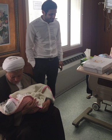 اذان گفتن آیت الله هاشمی در گوش یک نوزاد/ عکس